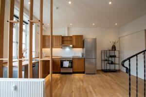 a kitchen with wooden cabinets and a stainless steel refrigerator at Stylish two floor Deluxe Apartment - 2 bedroom in Sønderborg
