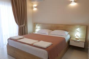 1 dormitorio con 1 cama grande y 2 toallas. en Saranda Luxury Apartments, en Sarandë
