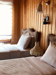 ウズンギョルにあるSelman Apart Hotelのベッドルーム1室(ベッド2台付)、壁にランプが備わります。