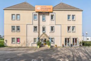 a large tan building with a sign on it at Premiere Classe Rouen Nord - Barentin in Barentin
