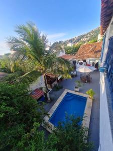 an overhead view of a swimming pool with a palm tree at Pousada Salvatore in Arraial do Cabo
