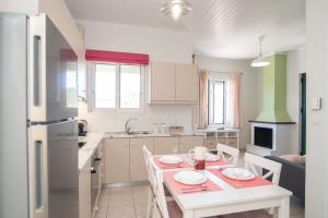 a kitchen with a table and chairs and a kitchen with a table and a kitchen at Antheon apartments in Vathi +24 photos