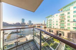 a balcony with a view of a river and buildings at Panoramic Riverside Facing - 2 Bed - 2 Bath - 2 Balconies - in London Nine Elms in London