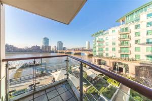 a balcony with a view of a river and buildings at Panoramic Riverside Facing - 2 Bed - 2 Bath - 2 Balconies - London Nine Elms in London
