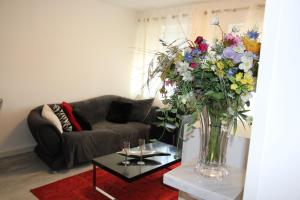 een woonkamer met een vaas met bloemen op een tafel bij Casa Pinos City in Friedrichshafen