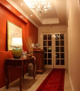 a hallway with a table and a lamp and a door at Arcadian Bed & Breakfast in Perth