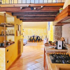 cocina con paredes amarillas y mesa con sillas en La locanda dei fedeli di Vitorchiano, en Vitorchiano