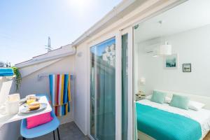 a room with a balcony with a bed and a table at Jele Rooms in Dubrovnik