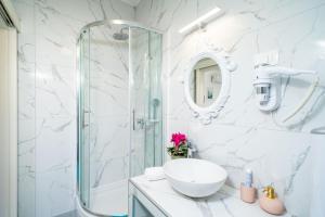 a white bathroom with a glass shower and a sink at Jele Rooms in Dubrovnik