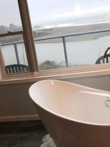 a white bath tub in front of a window at Hotel Breakers in Gualala