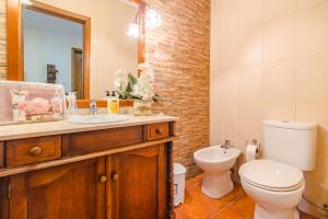 a bathroom with a toilet and a sink and a mirror at Araújo 111 - Traditional House in Leça do Balio +26 photos