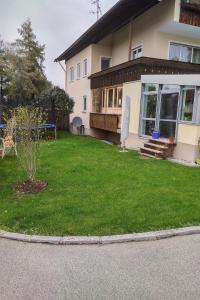 a house with a green lawn in front of it at Family's Nest Chiemsee in Chieming