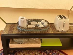 a basket and cups and a toaster on a shelf at Roslin Glamping in Roslin