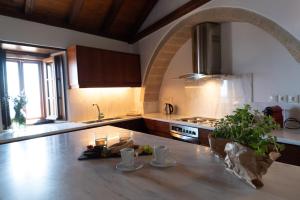a kitchen with an archway over a wooden counter top at Kyklamino Castlehouse in Monemvasia