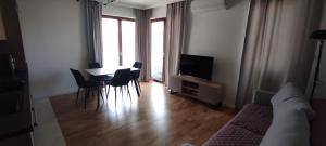 uma sala de estar com uma mesa e cadeiras e uma televisão em Apartament rodzinny w obiekcie Nautikka Park em Krynica Morska