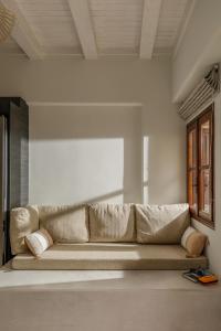 a large couch in a room with a window at Kamares Boutique Residence in Rethymno Town