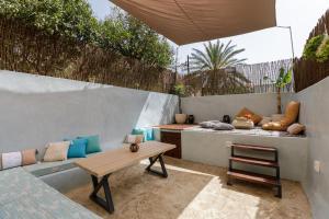 a patio with a wooden table and a bench at Kamares Boutique Residence in Rethymno Town