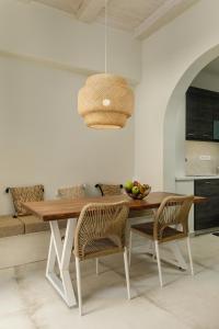 a dining room table with two chairs and a light fixture at Kamares Boutique Residence in Rethymno Town
