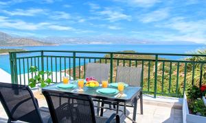 a table on a balcony with a view of the ocean at Istron Homes in Istron