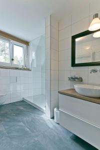 een witte badkamer met een wastafel en een spiegel bij Haus Nagel in Hinterzarten