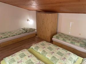 2 łóżka w pokoju z drewnianą podłogą w obiekcie Apartmán ANNA w mieście Dúbrava