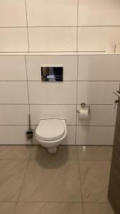 a bathroom with a white toilet in a stall at Hostel Ellwürder Hof in Nordenham
