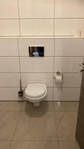 a bathroom with a white toilet in a stall at Hostel Ellwürder Hof in Nordenham +12 photos