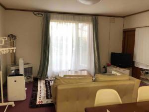 uma sala de estar com um sofá e uma janela em Guest House Hagoromo 39 - Vacation STAY 12003v em Kiyosato