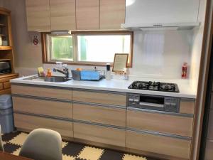uma cozinha com um fogão e um lavatório em Guest House Hagoromo 39 - Vacation STAY 12003v em Kiyosato