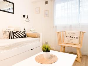 ein weißes Schlafzimmer mit einem Bett und einem Stuhl in der Unterkunft BEST LOCATION IN HEART OF PALERMO SOHO 2 BD in Buenos Aires
