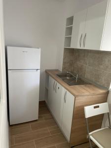 uma cozinha com um frigorífico branco e um lavatório em Militari Comfort Studio em Roşu