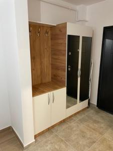 um armário com armários brancos e um espelho em Militari Comfort Studio em Roşu