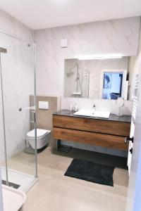 a bathroom with a sink and a toilet and a mirror at Luxury Apartment Maria Solare in Opatija
