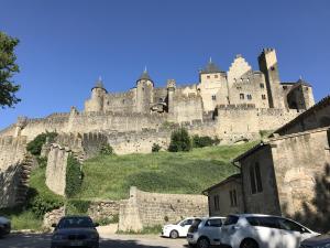 a castle on top of a hill with cars parked at Appartement climatisé avec terrasse in Carcassonne