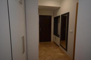 einen leeren Flur mit Tür und Spiegel in der Unterkunft Apartman Jocić in Vrnjačka Banja