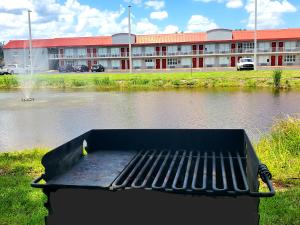 a bench in front of a building with a body of water at Vero Beach Inn & Suites Vero Beach I-95 in Vero Beach +47 photos