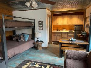 a living room with a bunk bed and a kitchen at Country Cottage at Camp Creek Cabins in Spanishburg