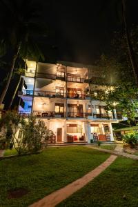 a lit up building with a lawn in front of it at Seaview Deepal villa in Unawatuna
