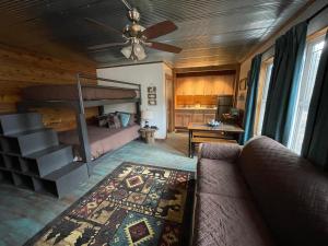 - un salon avec des lits superposés et un canapé dans l'établissement Country Cottage at Camp Creek Cabins, à Spanishburg