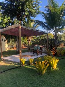 um pavilhão com uma mesa e um banco num quintal em Pousada Vila Rosa - Caraiva em Caraíva
