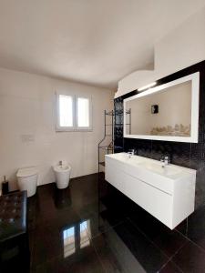 uma casa de banho com um lavatório branco e um WC. em Trullo di Puglia em Ceglie Messapica
