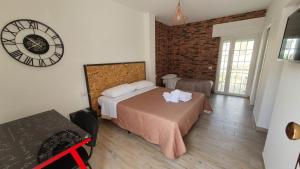 a bedroom with a bed and a clock on the wall at La Resilienza in Ginosa Marina