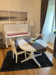 sala de estar con mesa y piano en Schloss Grabow, Resting Place & a Luxury Piano Collection Resort, Prignitz Brandenburg en Grabow