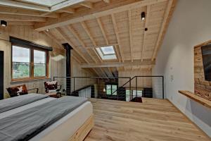 1 dormitorio con 1 cama en una habitación con techos de madera en Eibele Chalets, en Oberstaufen