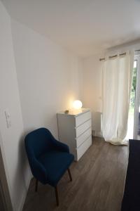 una camera da letto con una sedia blu e un comò di Le Temps d'une Escale à St Wary a Saint-Valéry-sur-Somme