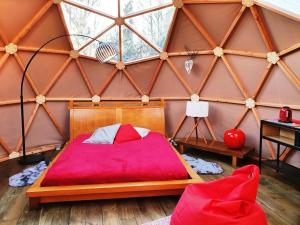 a bedroom with a red bed in a yurt at bulle d'amour à 500 m de la plage in Cancale