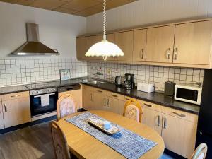 a kitchen with a wooden table with chairs and a tableablish at Thea in Gatersleben