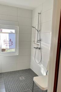 baño blanco con ducha y ventana en Thea, 