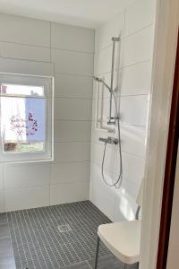 a white bathroom with a shower and a window at Thea 