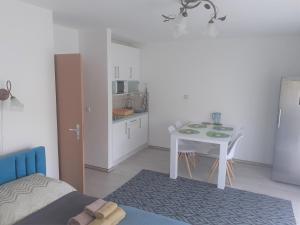 a room with a table and a small kitchen at Liliom apartman in Hévíz